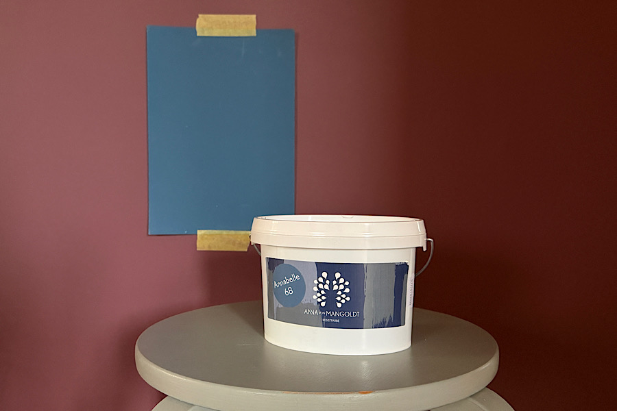 Farbmuster vor einer Wandfarbe